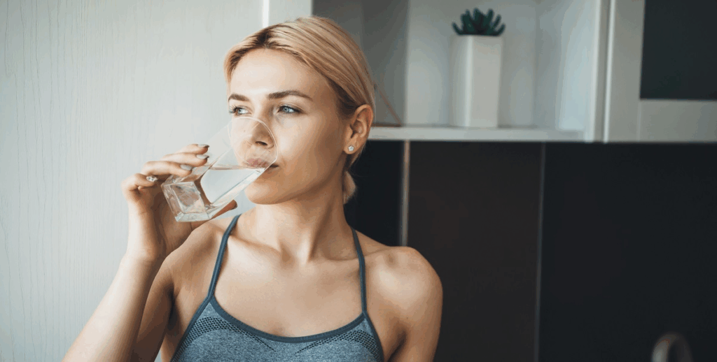 Woman drinking a glass of water dry mouth dentist in Asheville North Carolina