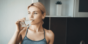 Woman drinking a glass of water dry mouth dentist in Asheville North Carolina
