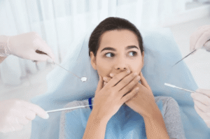 scared woman blocking her mouth from dental procedure sedation dentistry Asheville North Carolina